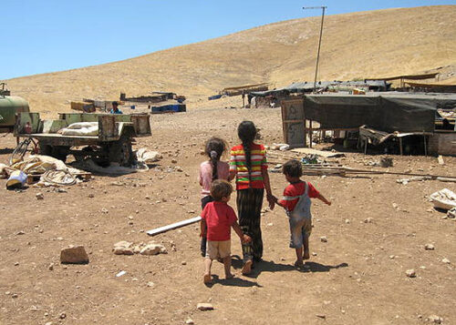 孩童站在他們隨時可能被拆除的屋宅外，約旦河谷Humsa（過去為Hadidiya）地區，2007年7月。c Amnesty International